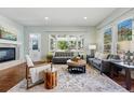 Inviting living room with hardwood floors, large windows, comfortable seating, and a decorative area rug at 6273 Torrey Ln, Arvada, CO 80403