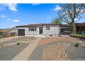 Front exterior of a charming home featuring a well-maintained yard, a one car garage, and sidewalk at 716 S Osage, Denver, CO 80223