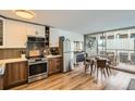 Modern kitchen with stainless steel appliances, wood cabinets, and a dining area with balcony access at 790 N Washington St # 1003, Denver, CO 80203