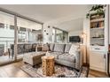 Bright living room featuring a gray sectional sofa, balcony access, a stylish coffee table, and a large mirror at 790 N Washington St # 1003, Denver, CO 80203