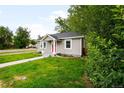 Charming home with gray siding, a red front door, and a well-manicured lawn at 4406 S Delaware St, Englewood, CO 80110