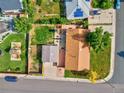 Overhead view of a home with a spacious backyard, featuring a deck, a play area, and mature landscaping at 701 Tucson, Aurora, CO 80011
