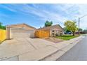 View of the detached garage and fenced yard with mature trees at 701 Tucson, Aurora, CO 80011
