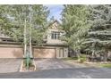 Two-story home featuring a two-car garage, a private porch, and mature trees at 31058 Big Bear Dr, Evergreen, CO 80439