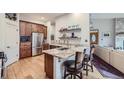 Modern kitchen with stainless steel appliances, hardwood floors, granite countertops, and an open floor plan at 31058 Big Bear Dr, Evergreen, CO 80439