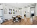 Light-filled dining area showcasing wood floors, stylish chandelier, and large windows at 5404 W 95Th Pl, Westminster, CO 80020