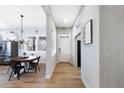 Bright entryway with light wood floors connects to dining area featuring a rustic table at 5404 W 95Th Pl, Westminster, CO 80020