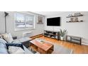 Comfortable living room featuring a modern couch, wood floors, and a large TV at 148 S Emerson St # 206, Denver, CO 80209
