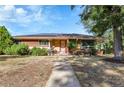 Single-story home with brick and siding exterior, solar panels, a walkway, and front porch seating at 435 Cody Dr, Lakewood, CO 80226