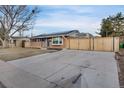 Quaint brick home with driveway and a wooden fence at 7266 S Birch St, Centennial, CO 80122