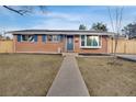 Inviting brick home featuring blue shutters, a bay window, and solar panels at 7266 S Birch St, Centennial, CO 80122