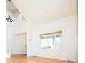 Bright living room with hardwood floors, high ceilings, and natural light from large windows at 13812 W 64Th Pl, Arvada, CO 80004