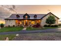 Charming home featuring stone facade, metal roof, well-manicured lawn, and welcoming front porch at 8456 N Sundown Trl, Parker, CO 80134
