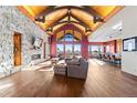 Spacious living room featuring stone fireplace, wood floors, vaulted ceilings, and stunning outdoor views at 8456 N Sundown Trl, Parker, CO 80134