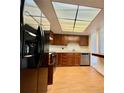Kitchen with a black refrigerator, stainless steel stove, wood cabinets, and a unique ceiling light at 13992 E Marina Dr # 303, Aurora, CO 80014