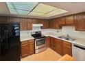 Well-lit kitchen showcases wood cabinets, stainless steel appliances, and black refrigerator at 13992 E Marina Dr # 303, Aurora, CO 80014
