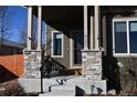 Inviting front porch featuring stone columns, dark wood accents, and clear address numbers at 9121 Harlequin Cir, Frederick, CO 80504