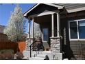 Charming front porch with stone accents, blooming tree, and well-maintained landscaping enhance curb appeal at 9121 Harlequin Cir, Frederick, CO 80504