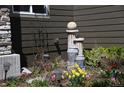 Beautiful backyard landscaping features a decorative fountain surrounded by colorful flowers and lush greenery at 9121 Harlequin Cir, Frederick, CO 80504