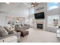 Spacious living room with a vaulted ceiling, fireplace, large television, and open access to the dining area at 510 W Prestwick Way, Castle Rock, CO 80104