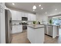 Modern kitchen featuring stainless steel appliances, white cabinetry, and an island at 5179 S Fairplay St, Aurora, CO 80015
