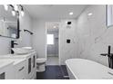 This bathroom features a soaking tub, modern fixtures, and a marble tiled shower at 951 E 10Th Ave, Broomfield, CO 80020
