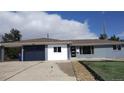 Charming single story home featuring a dark blue garage door and modern front door at 951 E 10Th Ave, Broomfield, CO 80020