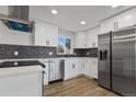 Modern kitchen features white cabinets, stainless steel appliances, and a stylish backsplash at 951 E 10Th Ave, Broomfield, CO 80020