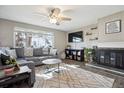 Bright and cozy living room featuring a fireplace, ceiling fan, and ample natural light at 1320 Quari St, Aurora, CO 80011