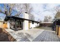 A white brick home showcasing a backyard space with a patio and detached garage at 2435 S Meade St, Denver, CO 80219