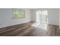 Bright living room featuring new laminate flooring, neutral paint, large windows, and sliding glass doors at 7755 E Quincy Ave # 308A5, Denver, CO 80237