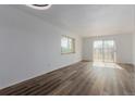 Bright living room with wood-style flooring and sliding glass door to balcony at 7755 E Quincy Ave # 308A5, Denver, CO 80237