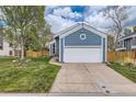 Ranch-style home featuring an attached two car garage, blue siding and front yard at 10743 W Berry Pl, Littleton, CO 80127