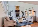 Bright living room with a vaulted ceiling, fireplace and staircase with white railings at 10743 W Berry Pl, Littleton, CO 80127