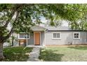 Attractive single-story home showcasing a gray exterior, a quaint front bench, and a neatly kept lawn at 1200 S Patton Ct, Denver, CO 80219