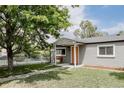 Well-maintained single-story home featuring a charming front porch and complemented by a lush, green lawn at 1200 S Patton Ct, Denver, CO 80219