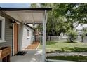 Cozy front porch featuring modern lighting, a stylish welcome mat, and a view of the meticulously maintained yard at 1200 S Patton Ct, Denver, CO 80219