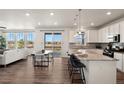 Bright, open-concept kitchen featuring white cabinetry, granite countertops, stainless steel appliances, and a spacious island with bar seating at 455 N Old Hammer St, Aurora, CO 80018
