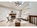 Cozy living room features a brick fireplace, vaulted ceiling, and skylight at 19383 E Chaffee Pl, Denver, CO 80249