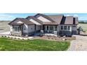 Beautiful single-Gathering home with stone accents, covered porch, and professionally landscaped front yard at 220 High Meadows Loop, Elizabeth, CO 80107