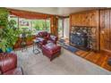 Inviting living room with a stone fireplace, wood walls, and cozy seating at 3384 Avenue F, Kittredge, CO 80457