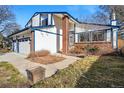 Charming two-story home featuring a three-car garage, blue trim, brick accents, and mature trees in a well-maintained neighborhood at 15974 E Loyola Dr, Aurora, CO 80013