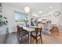 Charming dining area with hardwood floors, modern lighting, and a view to the updated kitchen at 9400 E Iliff Ave # 145, Denver, CO 80231