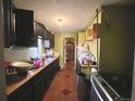 Galley kitchen featuring dark cabinets, linoleum floors, and an adjacent pantry at 3984 N Cook St, Denver, CO 80205