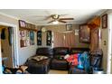 Comfortable living room with dark leather sectional couch, ceiling fan, and eclectic decor at 3984 N Cook St, Denver, CO 80205