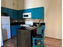 Bright kitchen featuring modern blue cabinets, tiled backsplash, and sleek countertops at 909 S Dawson Way # 19, Aurora, CO 80012