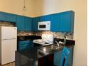 Bright kitchen featuring modern blue cabinets, tiled backsplash, and sleek countertops at 909 S Dawson Way # 19, Aurora, CO 80012