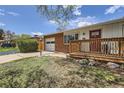 Charming single-story home with brick accents, a red door, an attached garage, and a cozy front porch at 2201 S Lowell Blvd, Denver, CO 80219