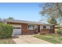 Single-story brick home with attached garage and a cozy front porch, perfect for curb appeal at 2201 S Lowell Blvd, Denver, CO 80219