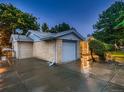 Attached garage with a paved driveway and manicured landscaping at 1145 W 101St Ave, Northglenn, CO 80260